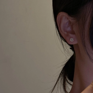 Minimalistische S925 Sterling Silber Sechskant-Ohrstecker an einem Model bei sanftem Licht