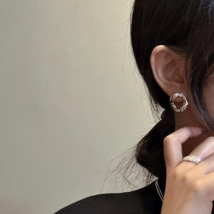 Boucles d'oreilles torsadées en argent S925 et bague texturée portées par un mannequin femme
