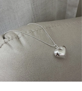 Detail of a high-polish S925 sterling silver hollow heart pendant on a classic ball chain