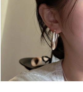 Gros plan d'une boucle d'oreille créole épaisse en argent S925 sur l'oreille