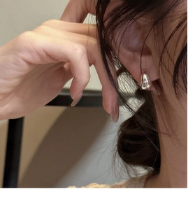 Close-up of polished silver teardrop hoop earrings on model for a minimalist daily look