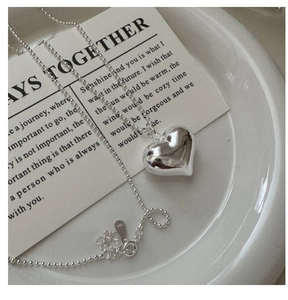 Detailed macro shot of S925 sterling silver hollow heart pendant on a bead chain