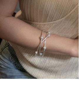 Detail of S925 sterling silver triple-layer beaded bracelet on a woman's wrist