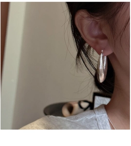 Gros plan de boucles d'oreilles créoles gouttes en argent S925 sur un mannequin