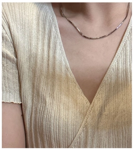 Detailed close-up of a minimalist 925 silver square snake chain necklace on a model's neck