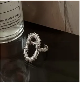 Detailed view of S925 sterling silver ring with a unique spiral hollow design on black base
