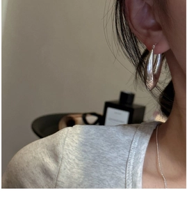 Détail de créoles épaisses en argent sterling S925 portées par un mannequin au style épuré
