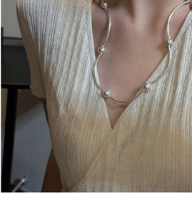 Detail shot of minimalist S925 sterling silver triple-layer bead necklace on a model