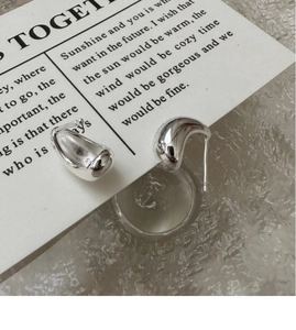 Macro detail of polished S925 sterling silver chunky C-hoop earrings on a card