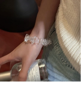 Détail du bracelet en argent S925 avec cristaux clairs sur le poignet d'un mannequin avec parfum