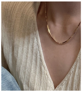 Detailed close-up of a 925 silver golden herringbone snake chain necklace on a model