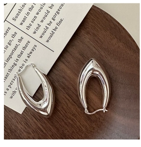 Détail macro de boucles d'oreilles créoles en U en argent S925 avec fini poli