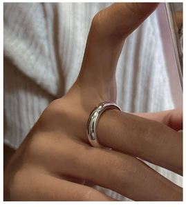 Gros plan d'une bague minimaliste en argent sterling S925 avec finition miroir lisse