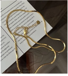 Detailed view of golden S925 sterling silver snake chain with lobster clasp and tag