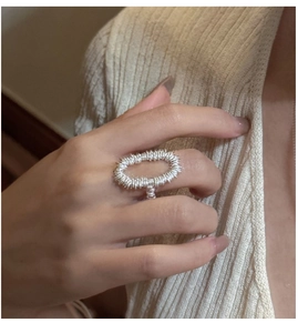 Macro shot of silver textured hollow oval ring showing modern artistic metallic patterns