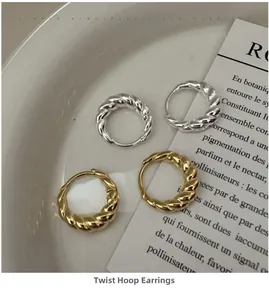 Close-up of gold and silver twisted hoop earrings on a ceramic tray with vintage paper