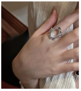 Close-up of a minimalist S925 sterling silver wavy ring with hollow oval center