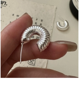 Close-up of S925 sterling silver C-shaped hoop earrings with spiral texture detail
