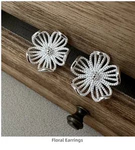 Makroaufnahme von S925 Sterlingsilber Blumenohrringen mit feiner Perlenstruktur der Blüten