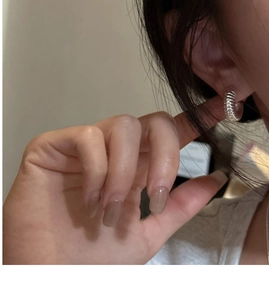 Close-up of woman wearing S925 silver chunky croissant hoop earrings with ribbed texture