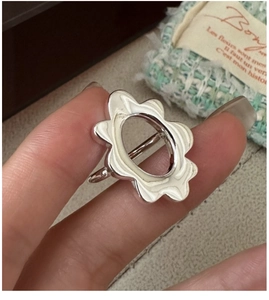 Macro shot of silver cutout wavy plumeria ring in minimalist polished silver finish