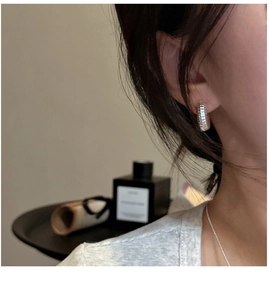 Detailed close-up of chunky ribbed S925 sterling silver hoop earrings worn on ear