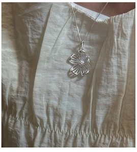 Vue détaillée du pendentif fleur en argent S925 avec pétales texturés et zircon