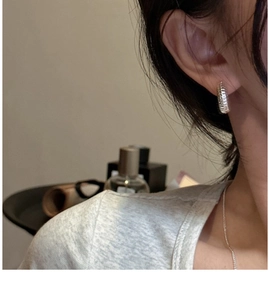 Close-up of S925 sterling silver hoop earrings with a twisted rope design on model
