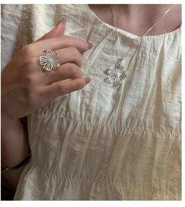 Gros plan sur l'ensemble bague et collier en argent S925 avec pétales texturés
