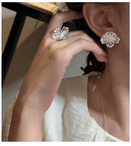 Detail eines S925 Silber Blumenschmuck-Sets mit hohlem Blütenring und Ohrsteckern am Modell
