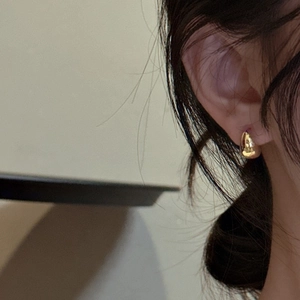 Minimalist gold teardrop stud earrings in S925 silver with a polished finish on ear