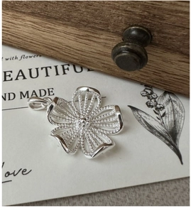 Détail d'un pendentif fleur en argent massif S925 avec texture perlée et anneau