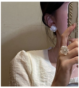 Detailaufnahme von S925 Sterlingsilber Hohlblumen Ohrringen und Ring an einem Model