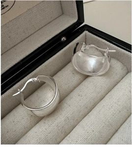Detailed view of polished S925 sterling silver oval hoop earrings in a luxury jewelry box