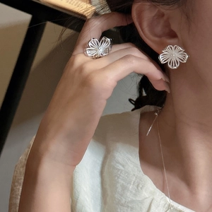 Elegantes S925 Sterling Silber Blumenohrringe und Ring Set am Modell bei warmem Licht