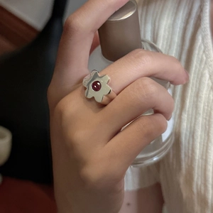 S925 sterling silver flower ring with red gemstone center worn on a model's hand
