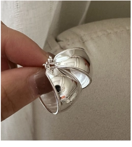 Detailed view of polished S925 sterling silver oval hoop earrings with mirror finish