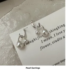 Close-up of S925 sterling silver earrings featuring twin pearls and elegant twist design