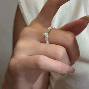 Detailed view of handcrafted silver butterfly pearl beaded ring on female finger
