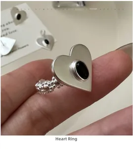 Macro detail of S925 sterling silver heart ring featuring a black gemstone and textured band