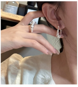 Detail of S925 sterling silver multilayer textured ring and hoop earrings on model