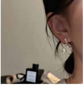 Close-up of minimalist S925 silver double pearl drop earrings on a model's ear
