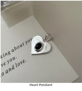 Vue macro d'un pendentif cœur en argent S925 avec une pierre noire sur une carte