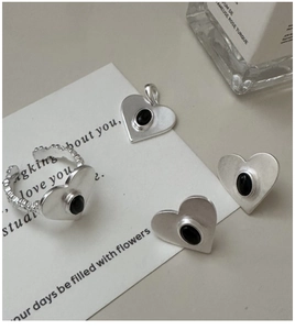 Detailed set of S925 silver heart jewelry with black onyx inlay on a white card background