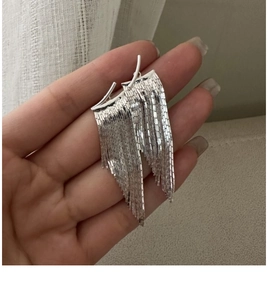 Detailed view of sterling silver tassel earrings with fine long metal fringe strands