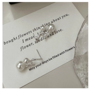 Macro detail of S925 sterling silver cross earrings with elegant pearls on a poem card