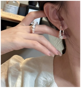 Detail showing 925 silver multi-layer twisted rope earrings and open ring on model