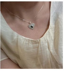 Détail macro du pendentif cœur en argent S925 dépoli avec pierre d'onyx noire ovale