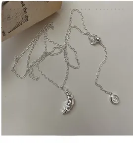 Detail view of silver croissant pendant necklace with spiral texture on adjustable chain