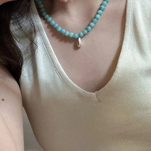 Detail of S925 silver water drop pendant on mint green beaded necklace for women
